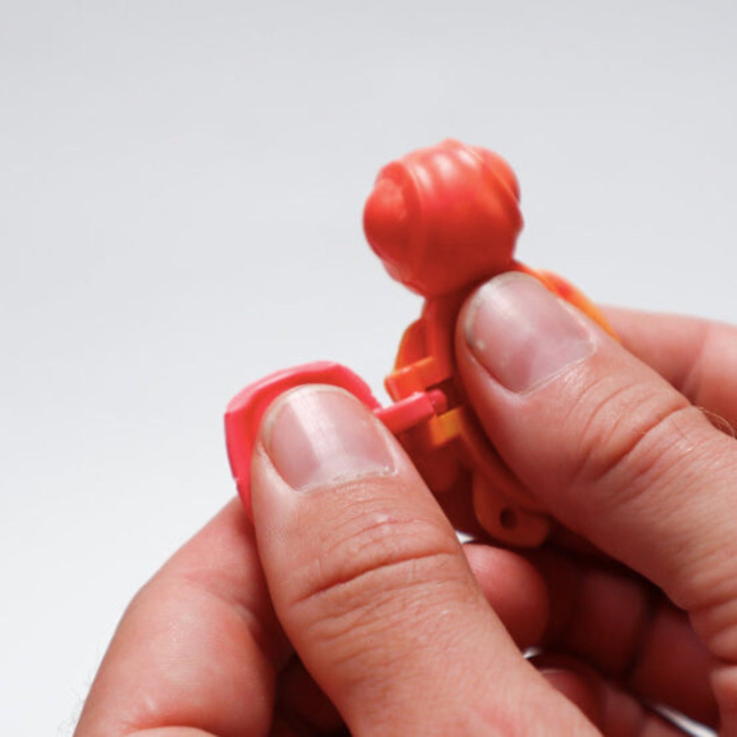 Person using an open Calm Buddi Turtle calming fidget toy in Lava