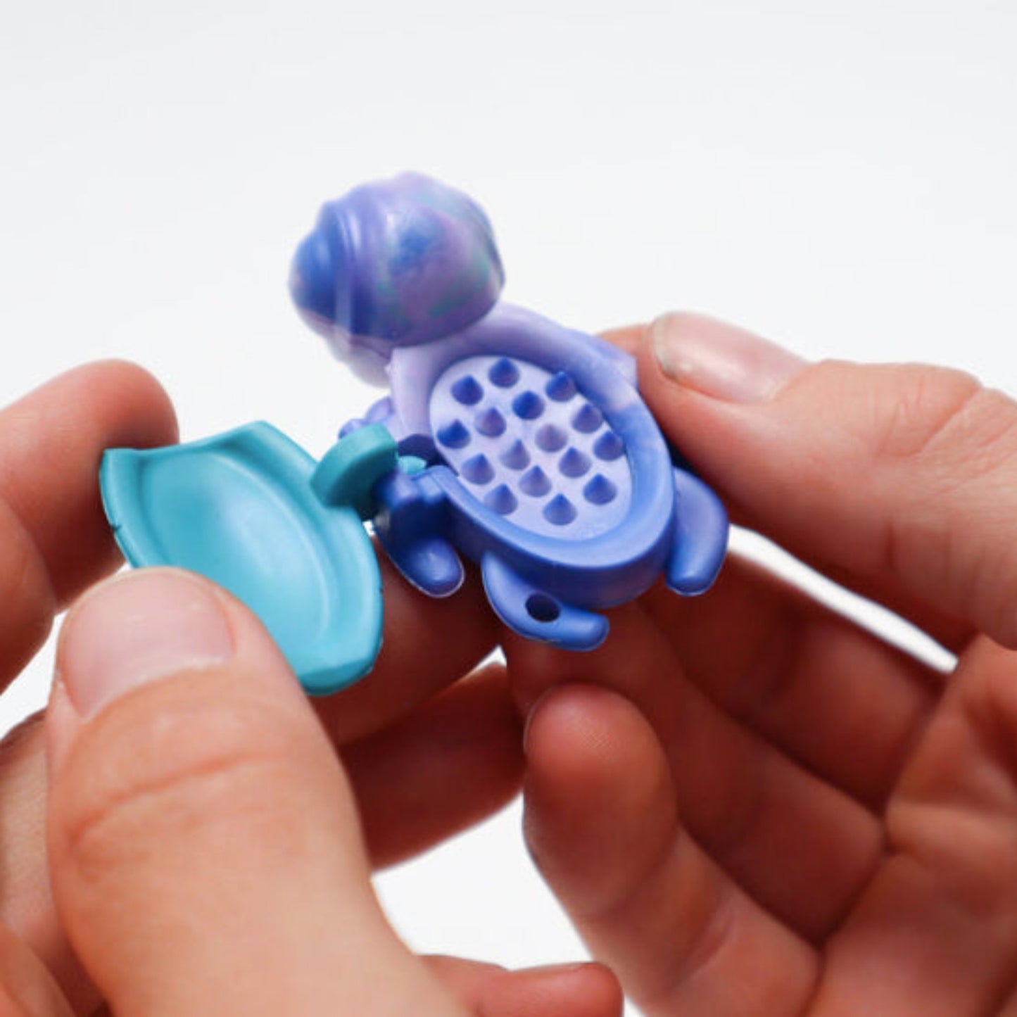 Person using an open Calm Buddi Turtle anxiety-relief fidget toy in Ocean