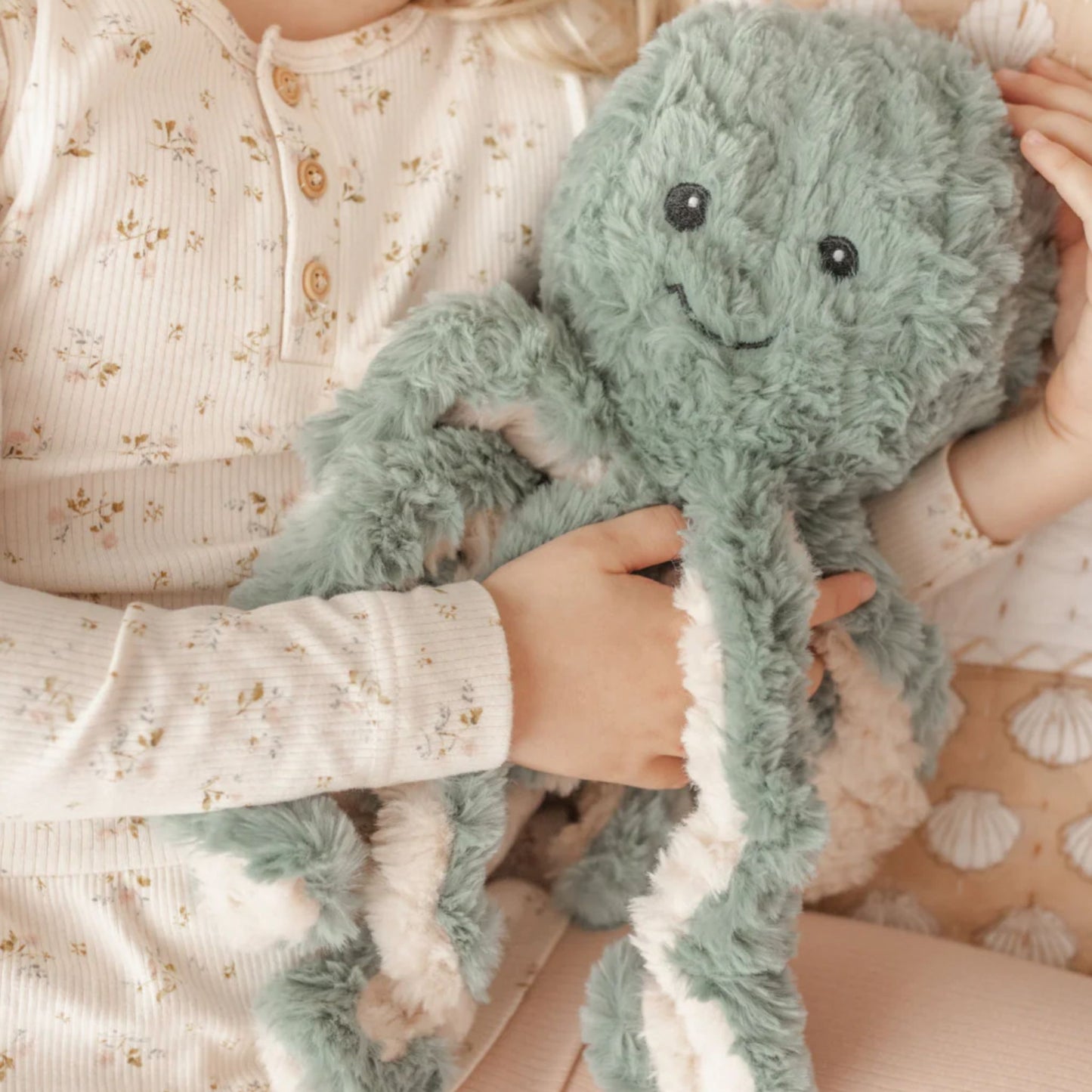 Child holding Ollie the Weighted Octopus weighted stuffed animal