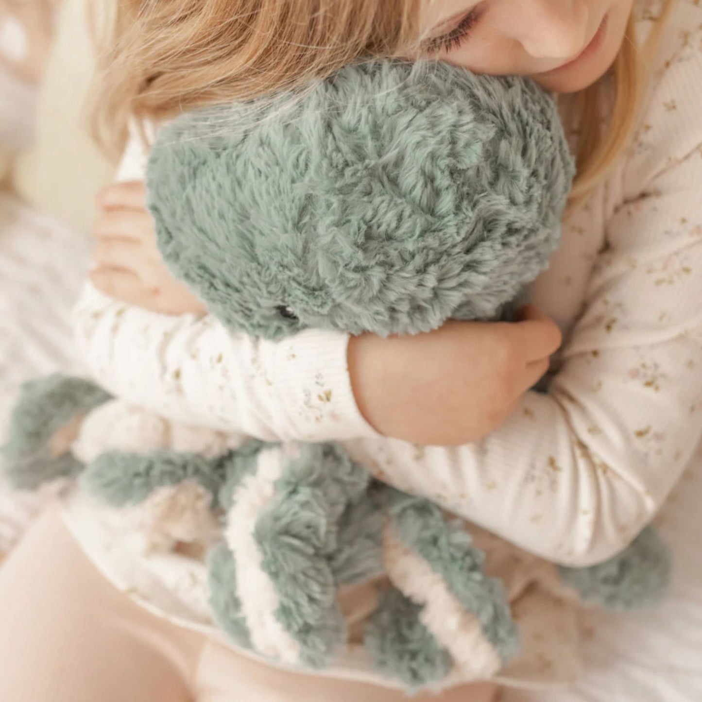 Girl hugging Ollie the Weighted Octopus weighted stuffed animal