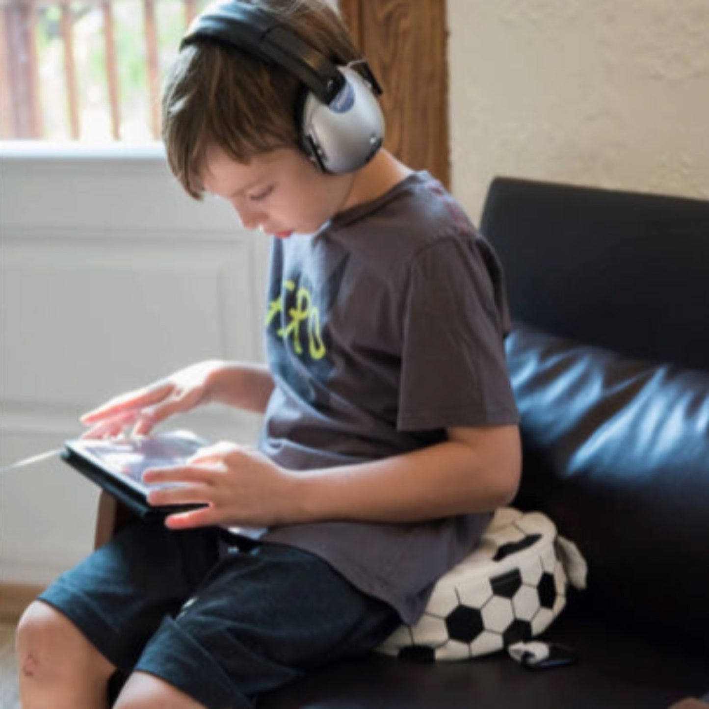 Child using the Senseez Vibrating Cushion, Originals calming cushion in the Soccer Ball design