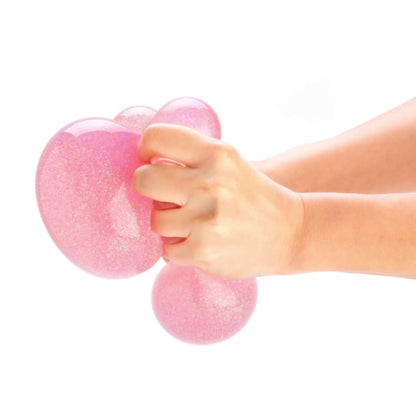 Person squeezing Smooshos Jumbo Glitter Ball Stress Ball in Pink