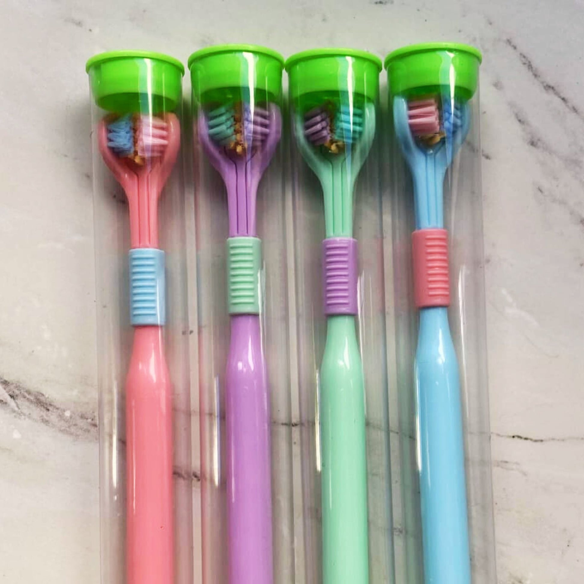 Four Tri-Sided Sensory Toothbrushes in tubes - Blue, Pink, Purple, Green